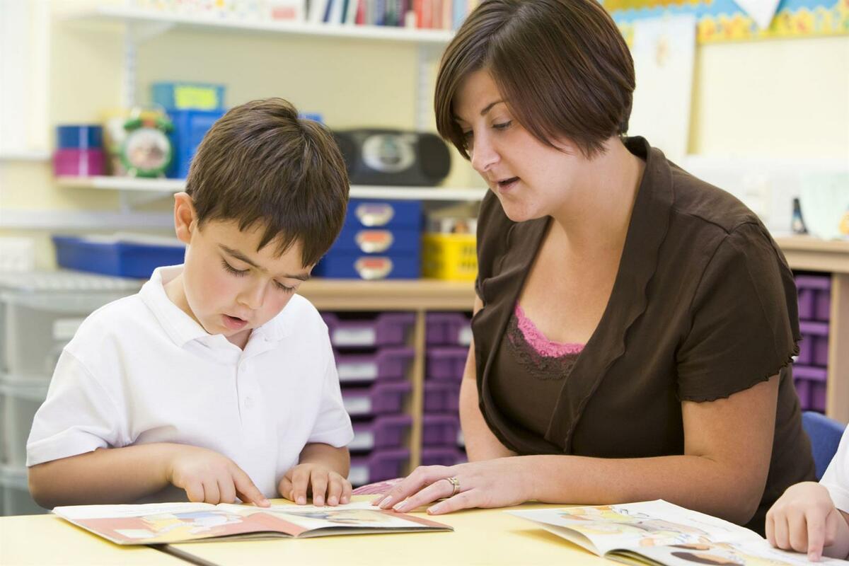 woman helping boy read