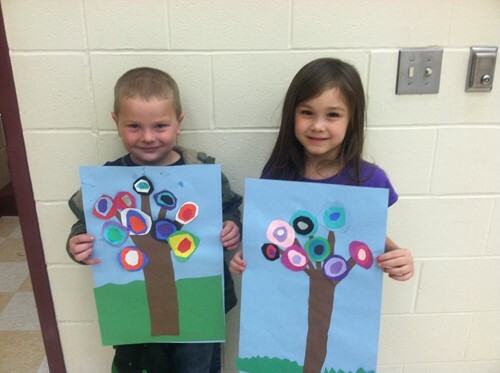 two kids holding up art work