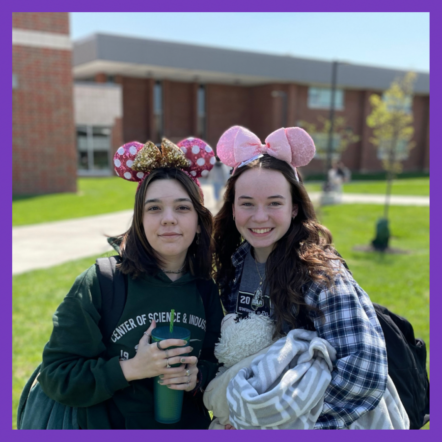 girls wearing mickey ears smiling for photo