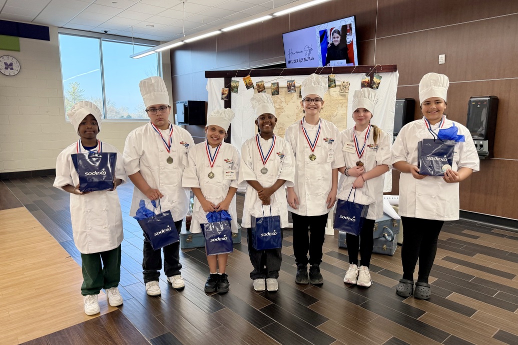 photo of student finalists with chef coat and hat on and medals around their neck