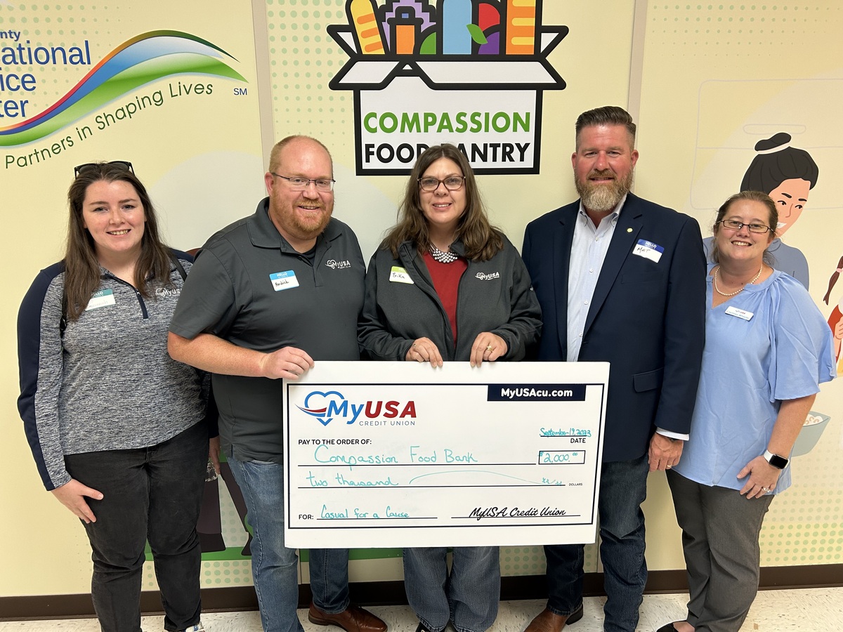 Five people from MyUSA Credit Union hold up large check.