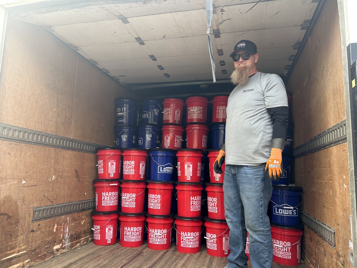 MCSD maintenance employee smiles for picture with truck full of Barricade Buckets behind him.