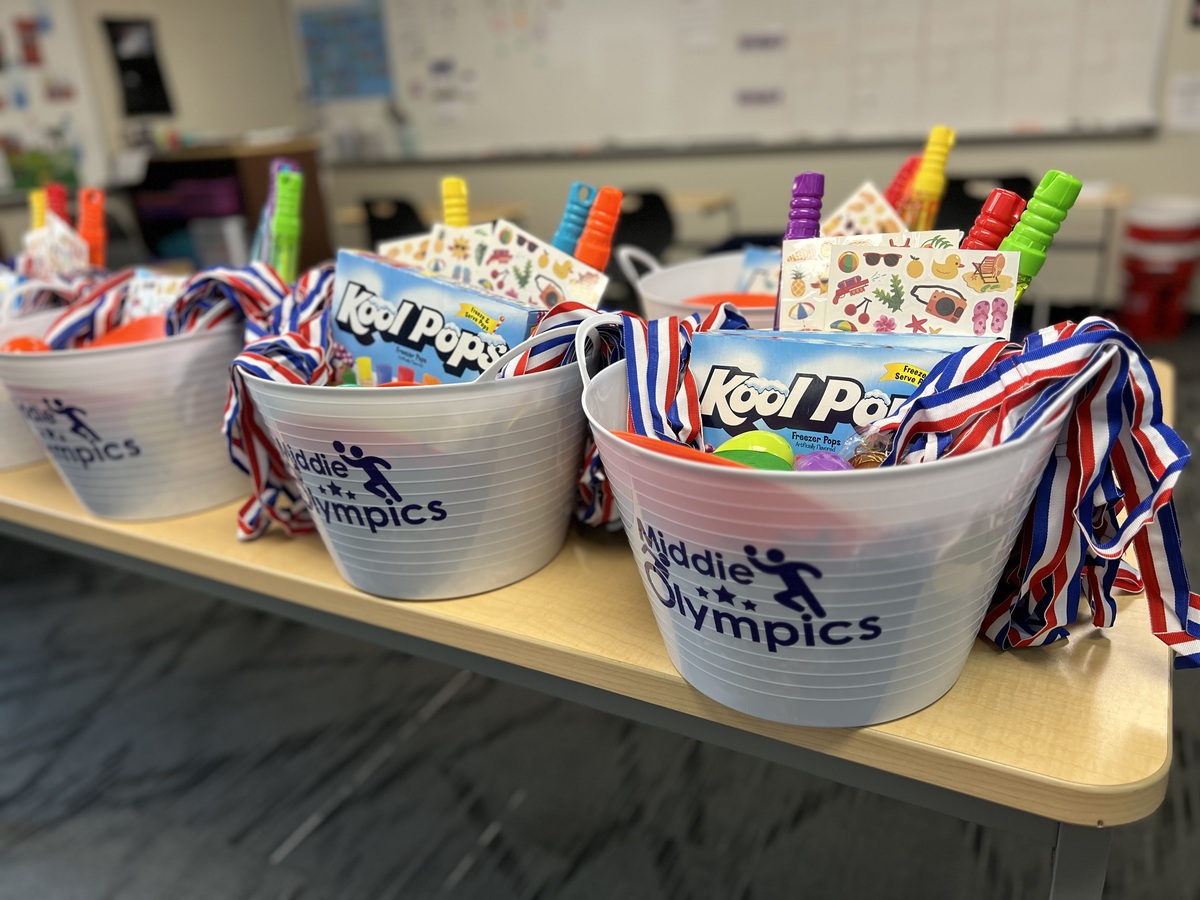 Photo of buckets that say "Middie Olympics" and are filled with celebration items