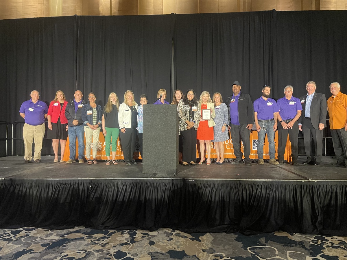 MCSD staff pose on stage with the 20th Anniversary Award