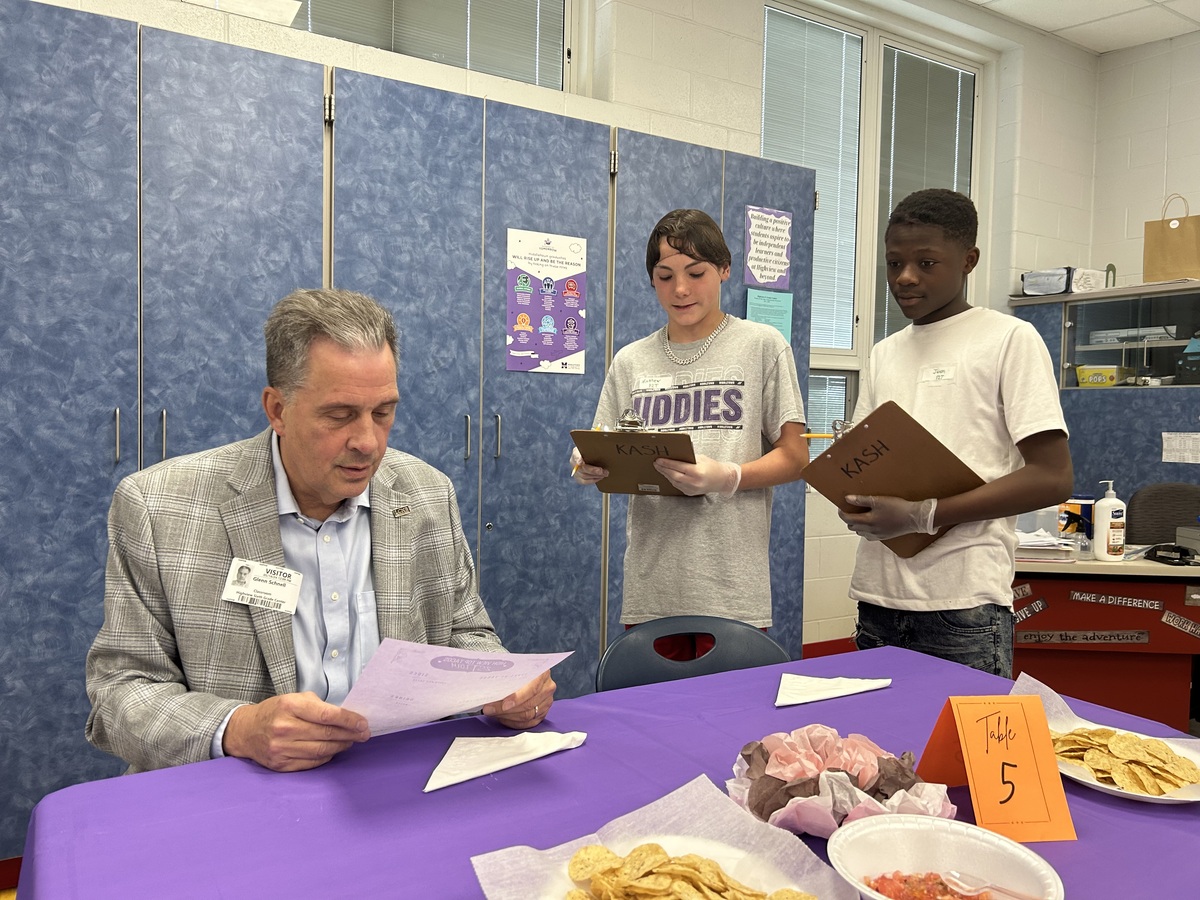 Students serve community member ordering tacos