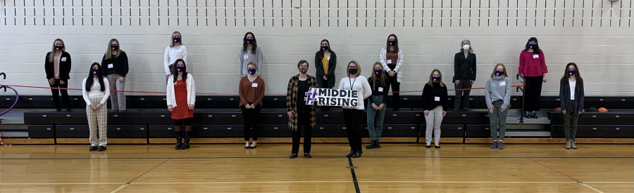 group spread out holding #MiddieRising sign