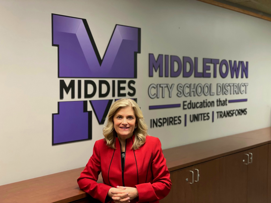 Deborah Houser in front of Middletown logo