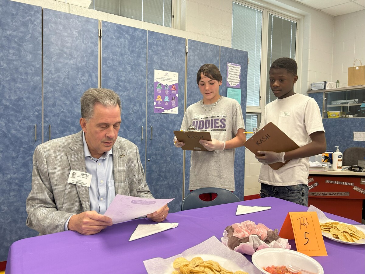 Students serve as waiters while serving a customer at their pop-up taco business.